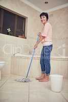 Beating the grime and dirt. Portrait of a woman mopping a bathroom floor.