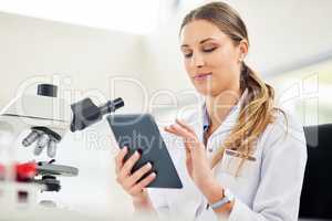 Technology is a vital tool for every researcher. Cropped shot of a young female scientist recording her findings on a digital tablet.