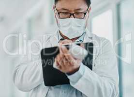 Need to get tested Call him. Shot of a doctor holding an infrared thermometer and writing notes during an outbreak.
