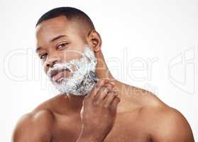 Use the right shaving products for smooth and glowing skin. Studio portrait of a handsome young man shaving his facial hair against a white background.