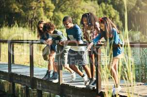 Nature is the new classroom. Shot of a group of teenagers standing on a bridge in nature at summer camp.