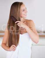 Brushing makes your hair grow faster. A gorgeous brunette woman brushing her healthy long hair.