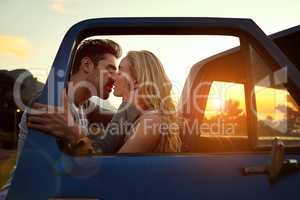 His kisses linger on her lips. Shot of an affectionate young couple on a roadtrip.