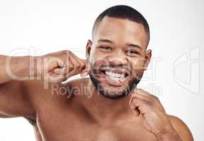 Enhancing beauty, health and hygiene. Studio portrait of a handsome young man flossing his teeth against a white background.