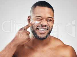 Pick up a good moisturiser for healthy skin. Studio portrait of a handsome young man applying moisturiser to his face against a white background.