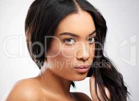 Youve gotta take your haircare seriously. Cropped portrait of an attractive young woman posing in studio against a grey background.