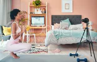 Now its time for some breathing exercises. Shot of a young woman recording herself while exercising at home.