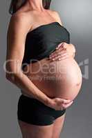 Expecting her arrival soon. A pregnant woman holding her tummy.