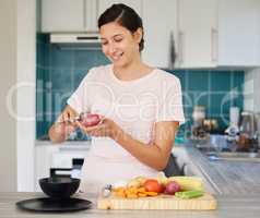 Peeling veggies brings me peace. Shot of a young woman peeling a potato in her kitchen.