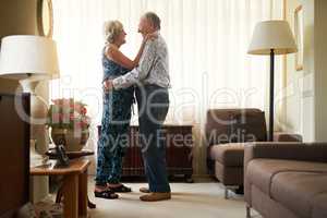 Lasting romance means always putting your best foot forward. Shot of a happy senior couple dancing together at home.