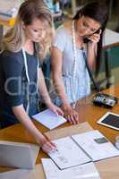 Theyre in demand. Two fashion designers standing at the front counter of their fabric shop.