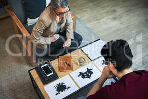 A way to scan the subconscious. Shot of a mature psychologist conducting an inkblot test with her patient during a therapeutic session.