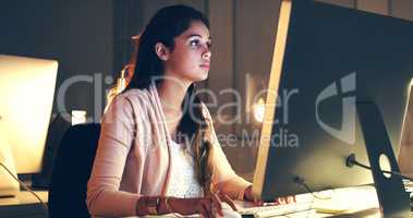 Completing the task with utmost concentration. Cropped shot of a beautiful young woman working at night in a modern office.