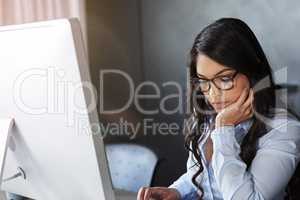 Putting in the work required. Shot of a young businesswoman sitting at her desk in the office.