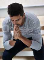 He knows where his strength comes from. Shot of a young man praying.