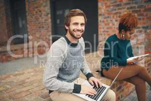 Getting some fresh air while studying. High angle shot of two young university students using a laptop to study on campus.