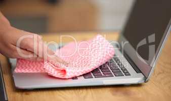 Getting in the crevices. Shot of a woman cleaning the dust from the laptop keyboard.