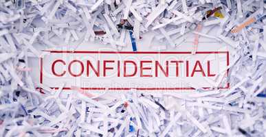 Keep it confidential. Studio shot of the word CONFIDENTIAL surrounded by shredded paper.