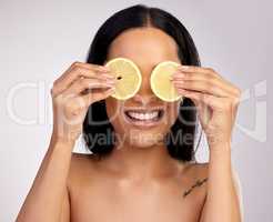 Natural treatments really do work. Studio shot of an attractive young woman posing with lemon slices over her eyes against a pink background.