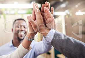 Take this day by the horns. Shot of a group of business people high fiving each other.