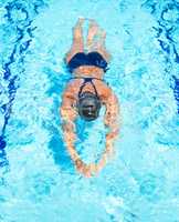 Gliding the remaining few metres. High-angle view of a female swimmer gliding through the pool.