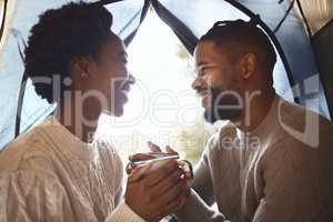 This is our sanctuary. Shot of a couple enjoying a cup of tea in their tent during a camping trip.
