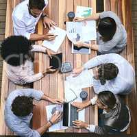 This is where we strategize, improvise and aim to succeed. High angle shot of a team of businesspeople having a meeting outside.