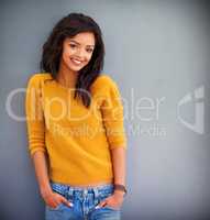 Her confidence speaks volumes. Studio portrait of an attractive young woman posing against a gray background.