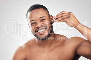 A face that is well hydrated is youthful. Studio portrait of a handsome young man applying serum to his face with a dropper against a white background.