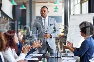 His speech has made a huge impact on his team. Shot of a group of businesspeople applauding during a presentation in an office.