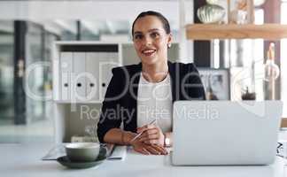 Ive created a positive working environment for myself. Portrait of an attractive young businesswoman feeling confident and cheerful while working inside her office.