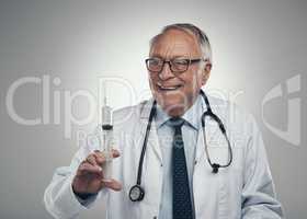 This treatment will reduce your inflammation. Shot of an elderly male doctor holding a syringe for injection in a studio against a grey background.
