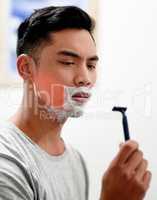 I really need to replace this. Shot of a young man at home getting razor burn on his face from shaving with a disposable razor.