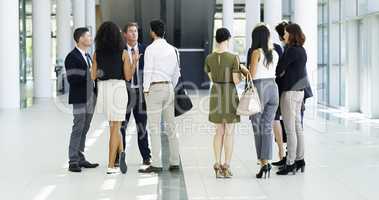 Business meetings can happen anywhere. Full length shot of a group of businesspeople standing in their workplace lobby.