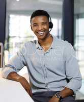 Have a query Im happy to help. Portrait of a young man using a headset in a modern office.