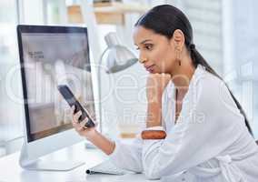 Designed to keep me discreetly, neatly in the corner. Shot of a young businesswoman scrolling on her cellphone in a modern office.