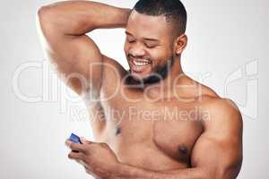 It keeps sweat under control and makes me smell great. Studio shot of a handsome young man spraying deodorant on his armpit against a white background.