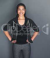 In shape and feeling great. Portrait of a fit young woman in sports clothing posing against a gray background.