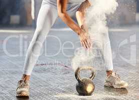 Dust off those workout clothes and get moving. Shot of an unrecognisable woman dusting her hands with chalk powder before working out with weights in a gym.