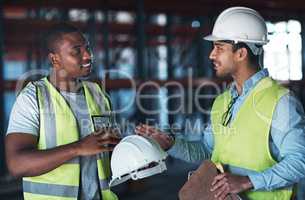 I dont want any problems. Shot of two young contractors standing in the warehouse together and having a discussion.