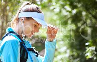 The perfect soundtrack to a perfect run. Shot of woman listening to music on earphones while out for a trail run.