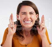 Did I make it. Studio shot of a young woman crossing her fingers in hope against a white background.