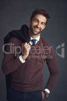 The style conscious man. Studio portrait of a stylishly dressed young man carrying his jacket against a gray background.