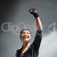 Pumped up for fitness. Shot of an excited young woman in sports clothing punching the air.