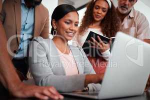 Please make a note of that. Shot of a group of businesspeople gathered around their manager using a laptop.