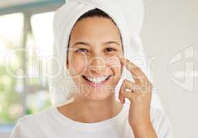 The only time I follow the rules is when it comes to skincare. Shot of a beautiful young woman applying moisturiser to her face.