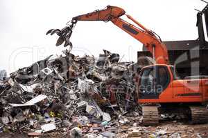 Processing industrial trash. Cropped shot of a crane at work in a dumpsite.