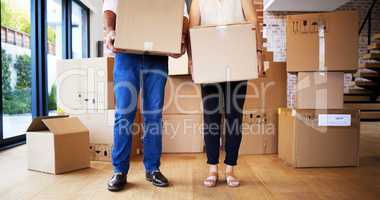 Boxes full of possessions, hearts full of priceless memories. Shot of an unrecognisable mature couple carrying boxes on moving day.