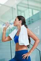 Stay hydrated, stay healthy. Shot of a fit young woman drinking water during her workout.