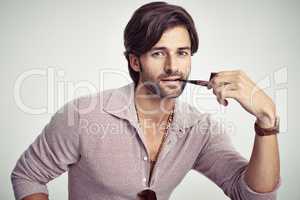 Groovy cool. A young man with 70s style sitting in the studio and smoking a pipe.